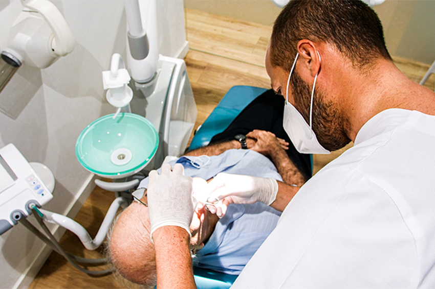 Odontólogo tratando a paciente Odontólogo tratando a paciente